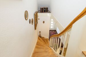 Der helle und einladende Treppenaufgang begeistert nicht nur Ihre Gäste sofort.