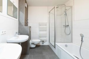 Das renovierte Bad mit separater Regendusche besticht durch die moderne Gestaltung.