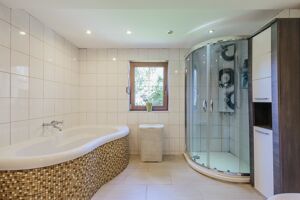 Das schön gefließte Bad mit großzügiger Badewanne...