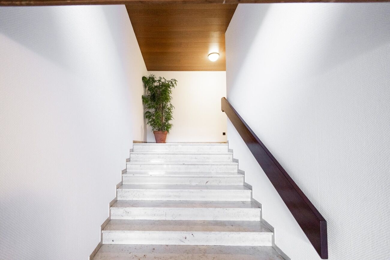 helle Steinfliesen zieren Foyer und Treppenhaus